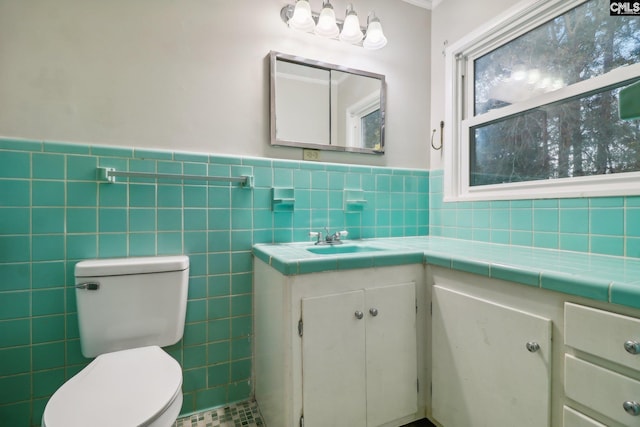 bathroom with vanity, tile walls, and toilet