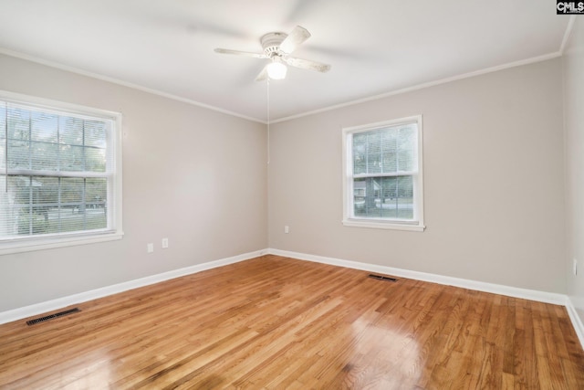 empty room featuring ceiling fan, light wood-type flooring, and ornamental molding