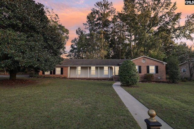 ranch-style home with a yard