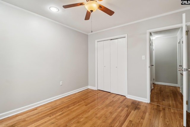 unfurnished bedroom featuring ceiling fan, a closet, crown molding, and light hardwood / wood-style flooring