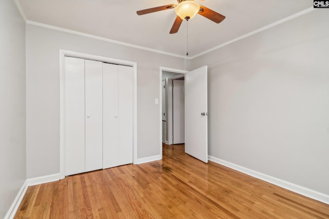 unfurnished bedroom featuring ceiling fan, a closet, crown molding, and light hardwood / wood-style flooring