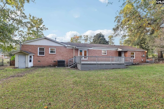 back of property with a yard, a shed, and a wooden deck