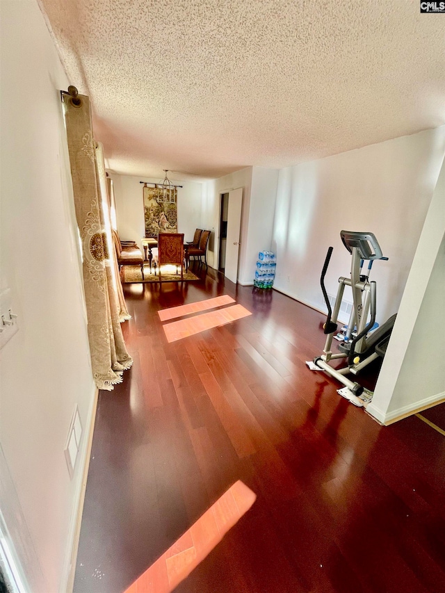 workout area featuring wood-type flooring and a textured ceiling