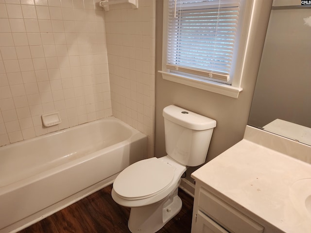 full bathroom with tiled shower / bath, vanity, wood-type flooring, and toilet