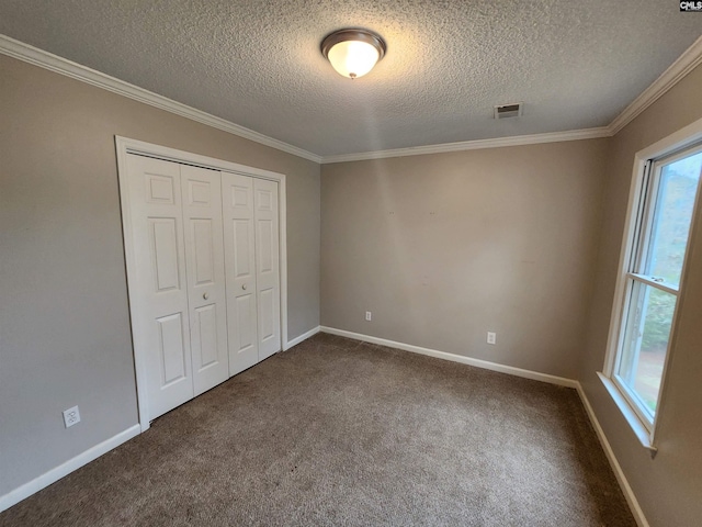 unfurnished bedroom featuring a closet, carpet, a textured ceiling, and ornamental molding