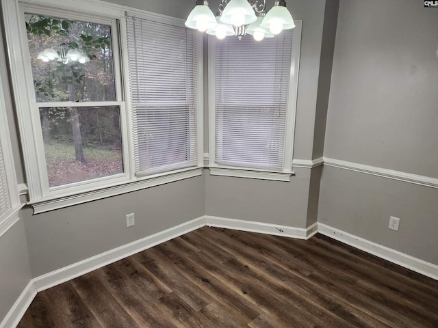 unfurnished dining area featuring a notable chandelier and dark wood-type flooring