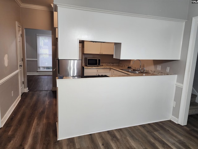 kitchen featuring white cabinets, dark hardwood / wood-style flooring, ornamental molding, and sink