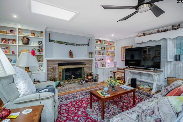 living room with a brick fireplace, ceiling fan, crown molding, wood-type flooring, and built in features