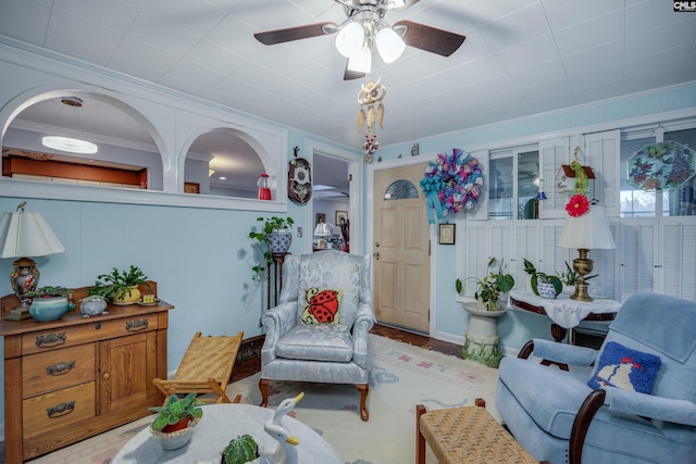 living room with crown molding and ceiling fan