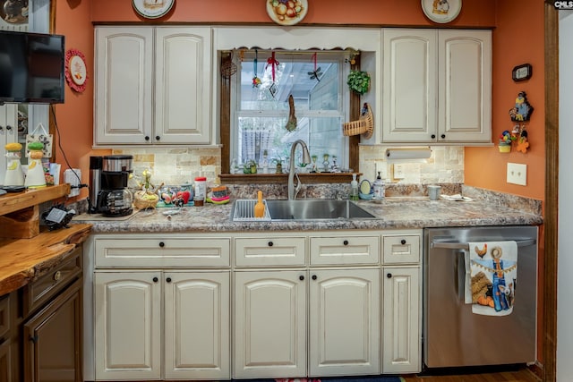 kitchen featuring cream cabinets, sink, stainless steel dishwasher, decorative backsplash, and wood-type flooring