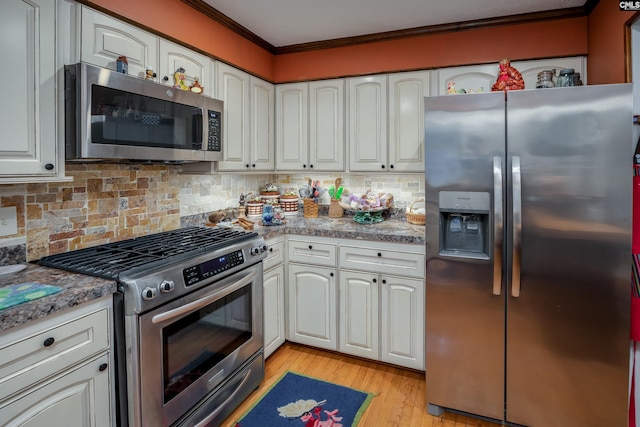 kitchen with appliances with stainless steel finishes, tasteful backsplash, crown molding, light hardwood / wood-style flooring, and white cabinetry