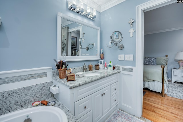 bathroom featuring vanity, wood-type flooring, and ornamental molding