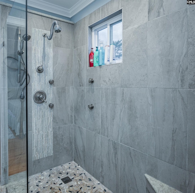 bathroom featuring ornamental molding and tiled shower