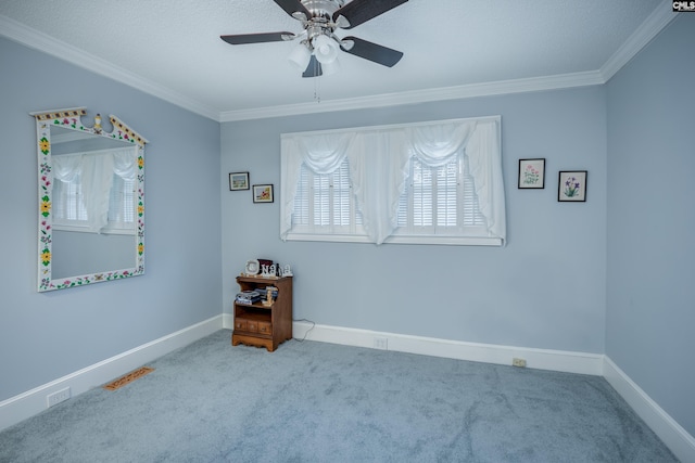 carpeted spare room featuring a textured ceiling, ceiling fan, and ornamental molding