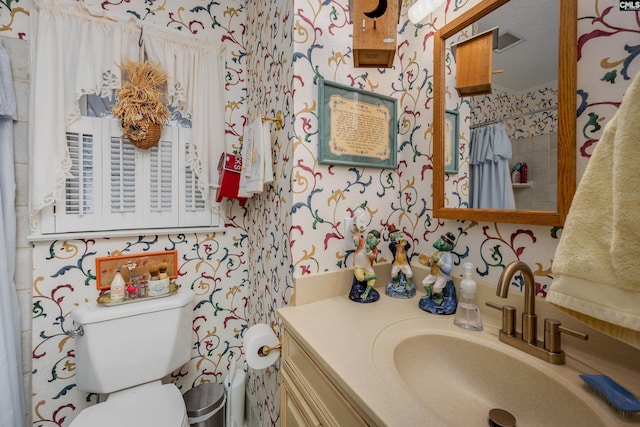 bathroom featuring a shower with shower curtain, a textured ceiling, vanity, and toilet