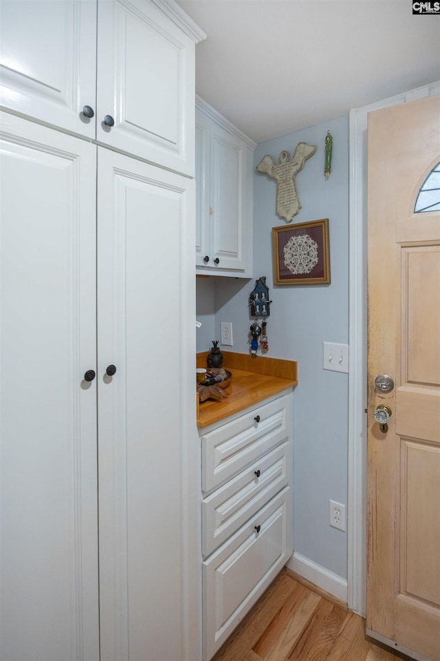 interior space with light wood-type flooring and white cabinetry