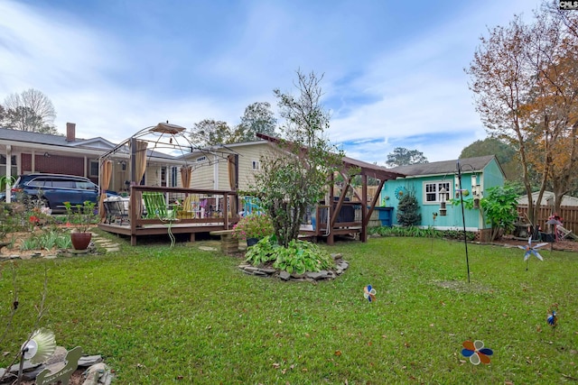 rear view of property featuring a gazebo, a lawn, and a wooden deck