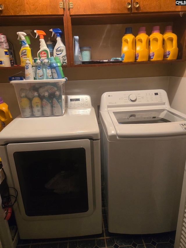 washroom featuring cabinets, independent washer and dryer, and dark tile patterned floors