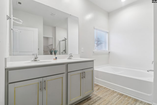 bathroom featuring hardwood / wood-style floors, vanity, and shower with separate bathtub