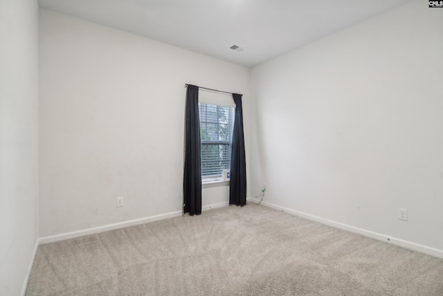 spare room featuring light colored carpet