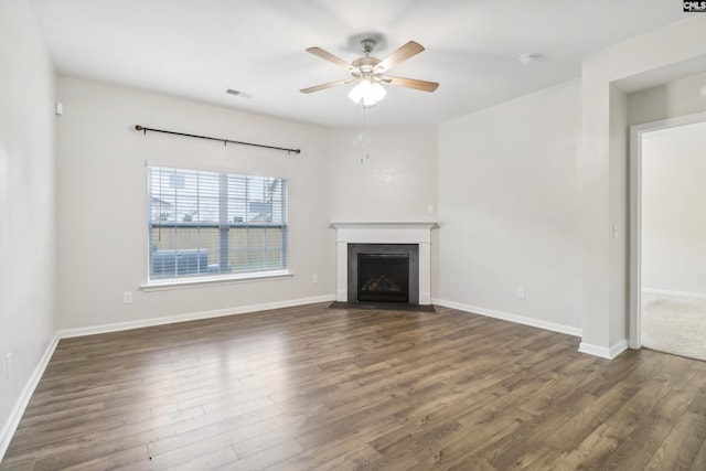 unfurnished living room featuring ceiling fan and dark hardwood / wood-style flooring