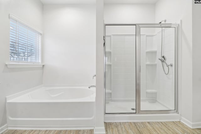 bathroom with hardwood / wood-style flooring and separate shower and tub