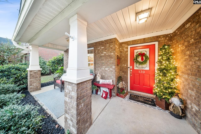 view of exterior entry featuring covered porch