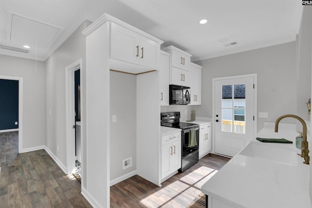 kitchen with electric range, dark hardwood / wood-style floors, white cabinetry, and sink