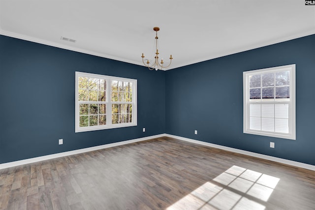 unfurnished room with a chandelier, hardwood / wood-style floors, and crown molding