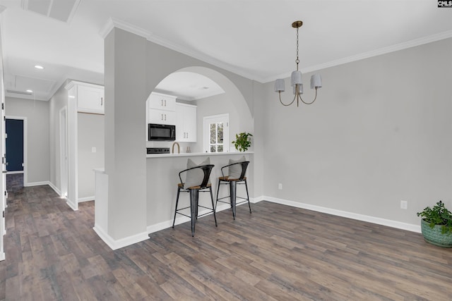 kitchen with crown molding, white cabinets, and dark hardwood / wood-style floors