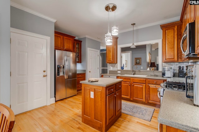 kitchen featuring a kitchen island, sink, appliances with stainless steel finishes, and light hardwood / wood-style flooring