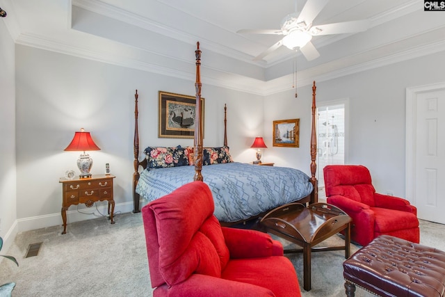 carpeted bedroom with ceiling fan, ornamental molding, and a raised ceiling