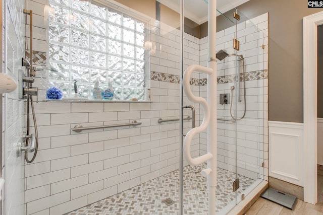 bathroom featuring a shower with shower door and ornamental molding