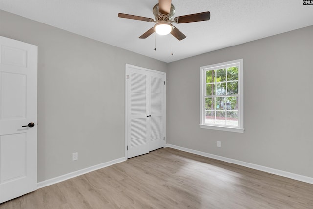 empty room with ceiling fan and light hardwood / wood-style floors