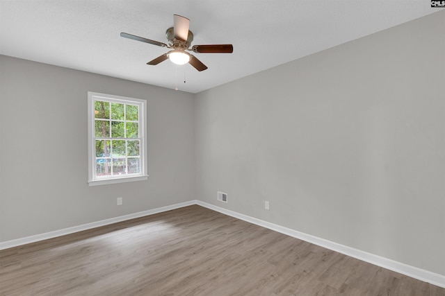 spare room featuring ceiling fan, light hardwood / wood-style floors, and a textured ceiling