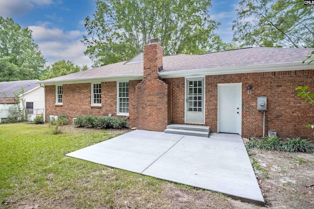 rear view of property with a yard and a patio area