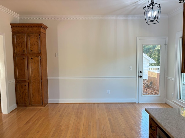 interior space with crown molding, an inviting chandelier, and light wood-type flooring