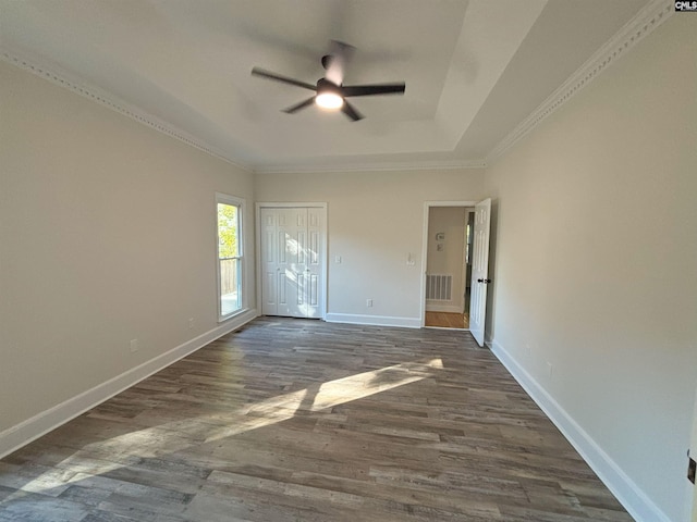 spare room with crown molding, ceiling fan, and dark wood-type flooring