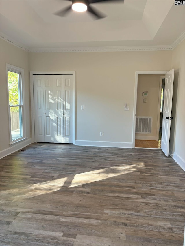 empty room featuring ceiling fan, dark hardwood / wood-style flooring, and crown molding