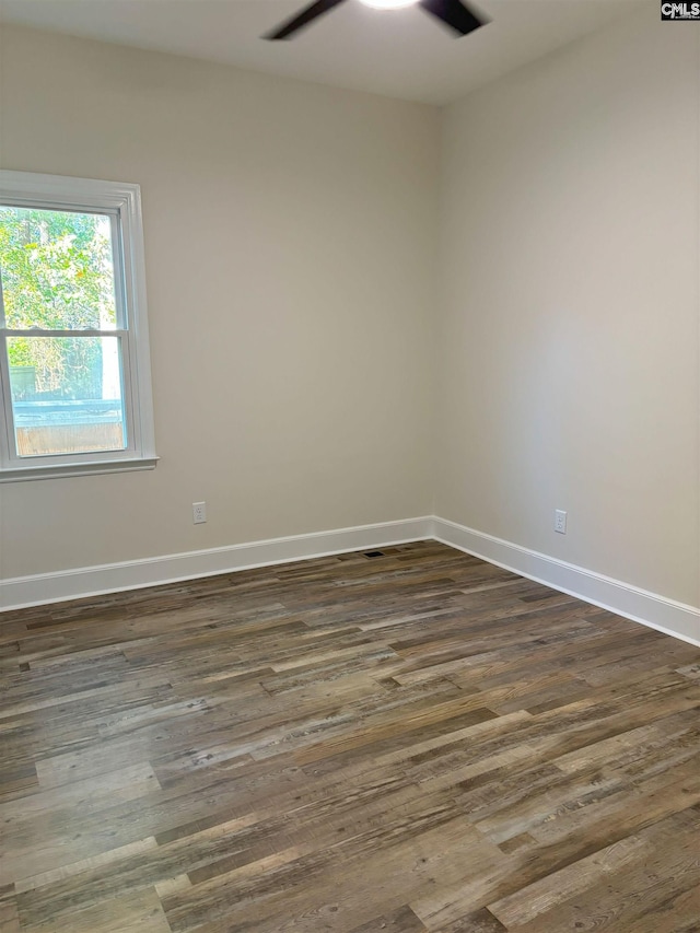 spare room with dark hardwood / wood-style flooring and ceiling fan