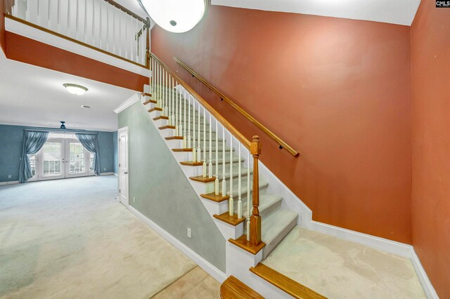 stairs featuring carpet, crown molding, and french doors