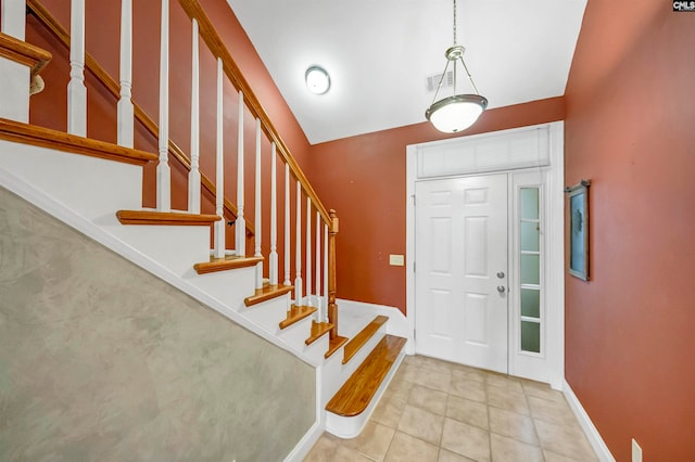 entryway featuring lofted ceiling and light tile patterned floors