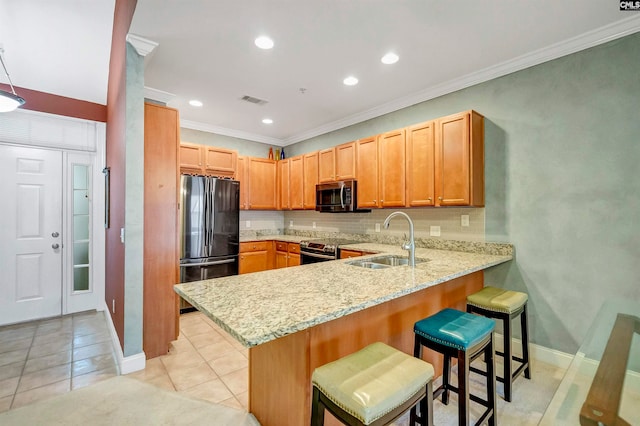 kitchen with kitchen peninsula, light stone counters, stainless steel appliances, sink, and light tile patterned flooring