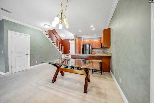 dining room featuring light colored carpet, crown molding, and a chandelier