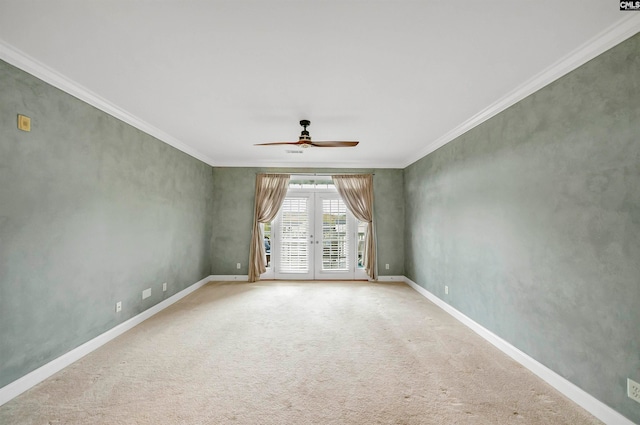 carpeted empty room featuring ceiling fan, ornamental molding, and french doors