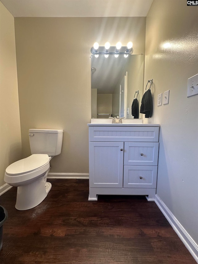 bathroom with vanity, wood-type flooring, lofted ceiling, and toilet