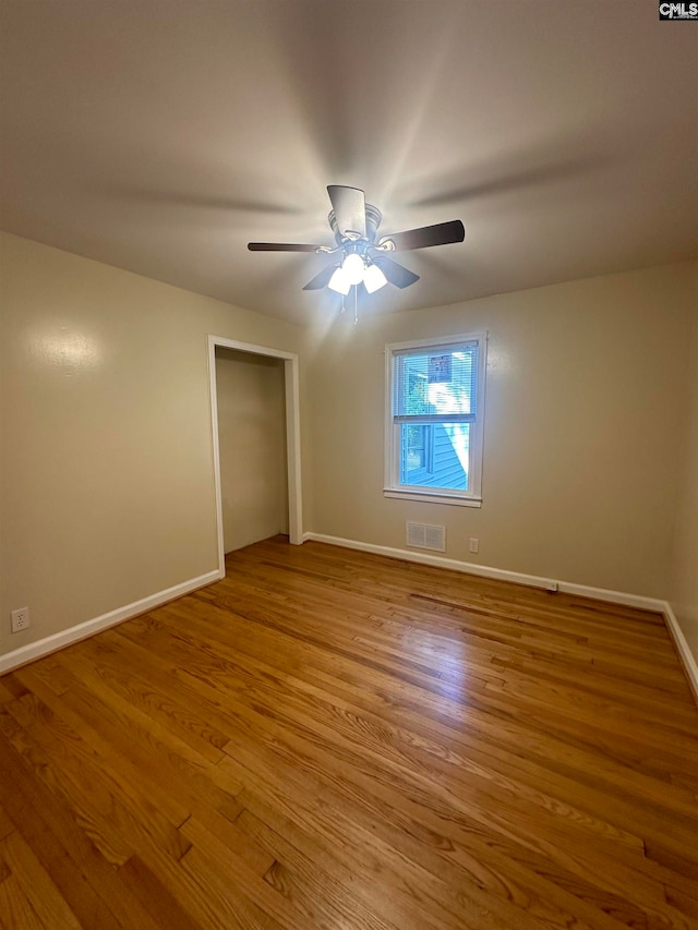 unfurnished bedroom with ceiling fan, a closet, and light hardwood / wood-style floors