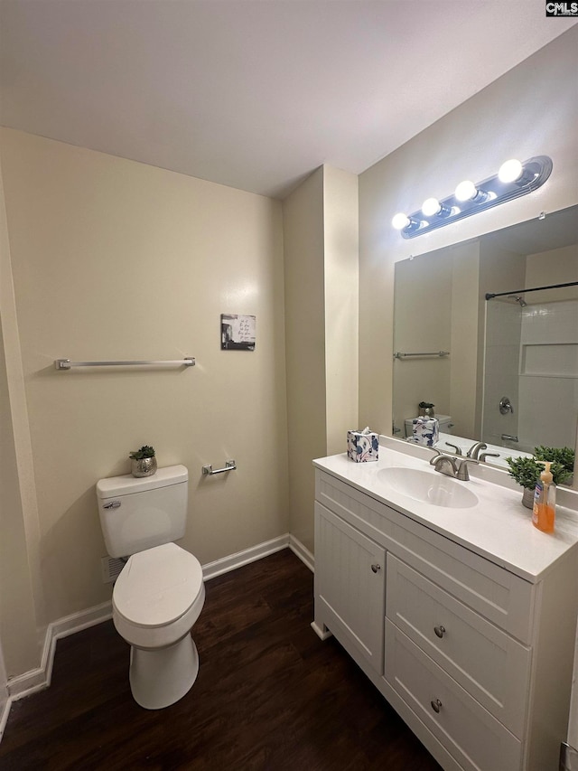 full bathroom with hardwood / wood-style floors, vanity, shower / bath combination, and toilet