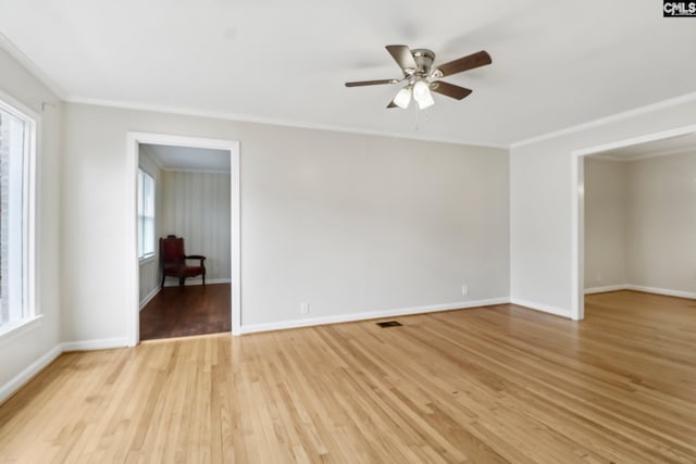 empty room featuring crown molding, plenty of natural light, ceiling fan, and light hardwood / wood-style floors