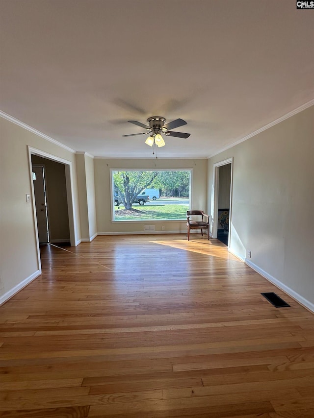 empty room featuring light hardwood / wood-style flooring, ceiling fan, and crown molding